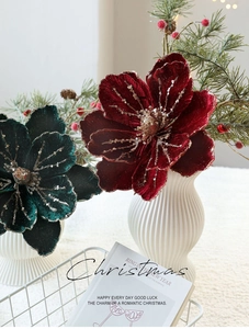 Deep red and green velvet Christmas flowers with gold glitter in a white textured vase