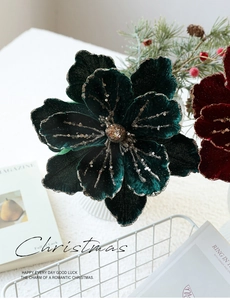 Detail of red and green flocked Christmas poinsettia with glitter petals in a basket