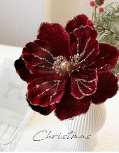 Detail of elegant velvet burgundy magnolia flower with sparkling gold glitter edges