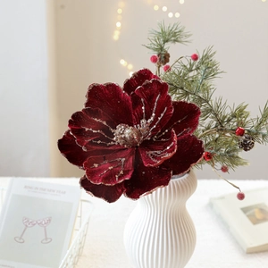 Luxurious burgundy velvet magnolia flower with gold glitter in white vase for Christmas decor