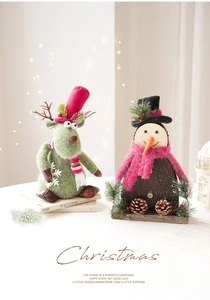 Detailed view of felt reindeer and wooden snowman figurines in festive Christmas setting