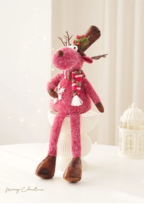 Close-up of pink felt Christmas reindeer figurine with striped scarf and festive berry hat