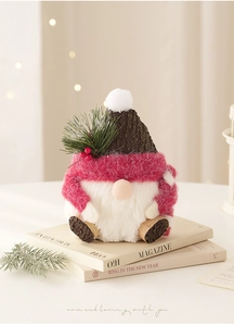 Detailed view of pink knitted Christmas gnome with bark-textured hat and pine needles