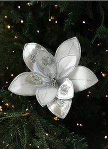 Detailed view of silver fabric Christmas flower with glitter and beads on green tree