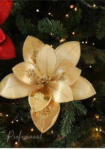 Close-up of golden silk artificial Christmas flower with glitter on festive tree branches
