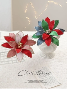 Close-up of luxury fabric poinsettia with glitter edges and golden bead center details
