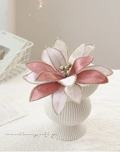 Pink velvet Christmas poinsettia with gold edges in a white striped art vase decor