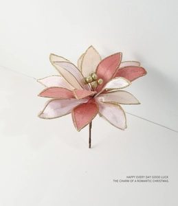Detailed close-up of velvet Christmas flower with gold glitter edges and berry center