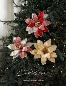 Detail of elegant Christmas fabric flowers with gold edges on festive tree branches
