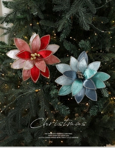 Detailed view of red and blue velvet poinsettia flowers with gold trim on a Christmas tree
