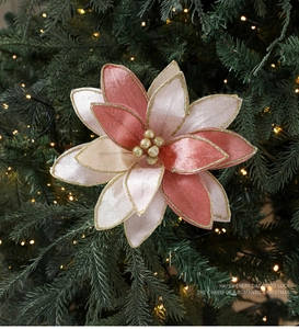 Pink and deep red velvet Christmas flower with gold glitter edges on a lit xmas tree