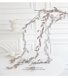 Champagne gold Christmas garland with glitter hanging on a branch in a minimalist room