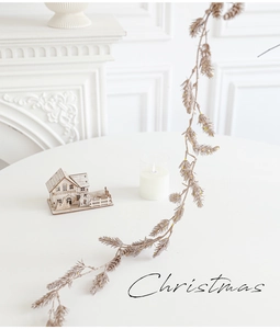Close-up of champagne gold glitter Christmas pine branch on a white fireplace table