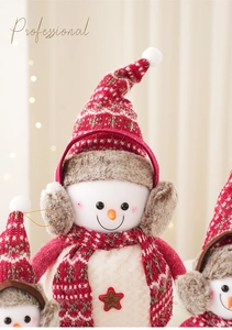 Détail de la poupée bonhomme de neige en peluche avec bonnet et badge étoile Welcome