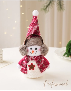 Détail du bonhomme de neige en peluche avec bonnet tricoté et badge étoile WELCOME