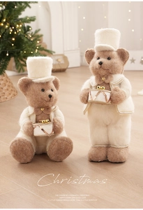 Detail of plush Christmas bear figurines with gold trim and drums in a cozy festive setting