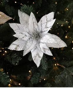 Close-up of 28cm white Christmas flower with silver glitter on a warm-lit holiday tree