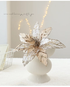 Detail of a champagne glitter poinsettia artificial flower in a white textured vase