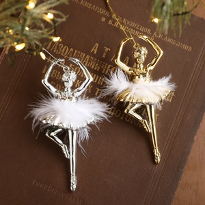 Set of gold and silver ballet girl Christmas ornaments with white feathers on vintage book