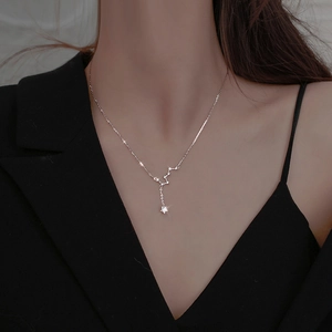 Detail of silver Big Dipper necklace with star pendant and zircons on a model