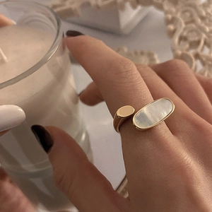 Bague ouverte dorée minimaliste avec incrustation de nacre portée par une femme