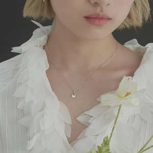 Elegant silver teardrop pendant necklace with cubic zirconia on a female model