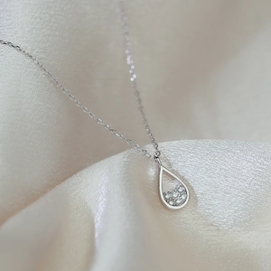 Exquisite teardrop zircon pendant necklace with silver chain on silk background