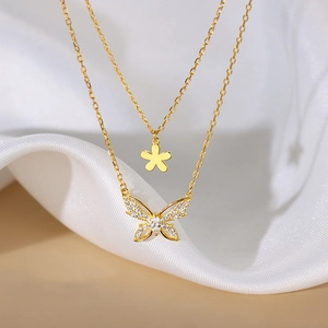Detail of double-layer gold necklace with butterfly pendant and white cubic zirconia