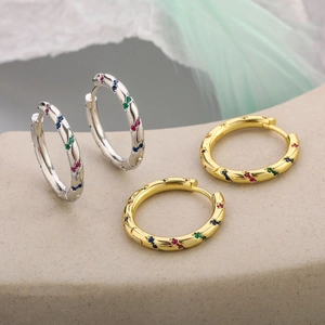 Macro detail of S925 silver twist hoop earrings with colorful inlaid zircon stones