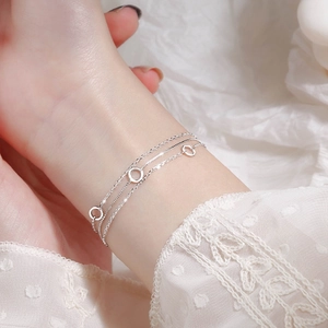Close-up of minimalist triple-layer 925 silver bracelet with hollow circle charms