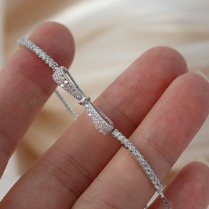 Macro detail of S925 silver bow bracelet featuring micro-pave cubic zirconia stones