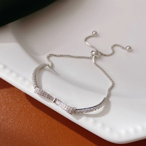 Close-up of S925 silver bow bracelet featuring pavé zircons and adjustable slider clasp