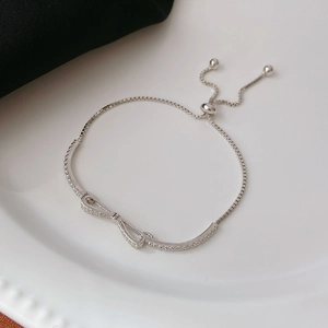 Elegant S925 sterling silver bow bracelet with sparkling cubic zirconia on a white plate