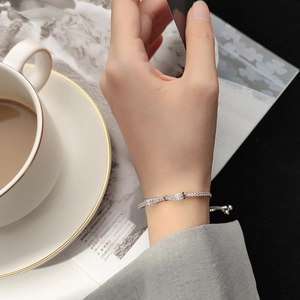 Close-up of S925 silver bow bracelet with zircons and adjustable slider on a model wrist
