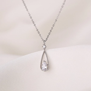 Elegant silver waterdrop necklace with pear-cut zircon on soft silk background