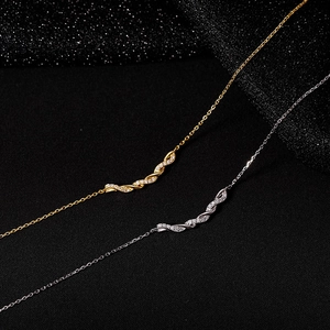 Macro shot of 925 silver wave pendants with pavé zircon stones on black fabric