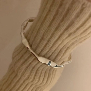 Minimalist S925 silver ring with irregular wave texture on beige knit background