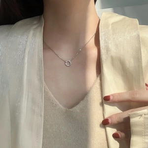 Close-up of minimalist silver hoop necklace with micro-diamonds on a woman collarbone