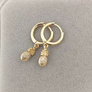 Close-up of gold pineapple hoop earrings with sparkling micro-pave cubic zirconia crystals