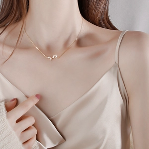 Elegant 925 silver heartbeat necklace with gold finish and sparkling heart pendant on model