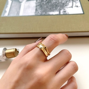 Detail of vintage irregular gold-tone ring with textured hammer finish on model's hand