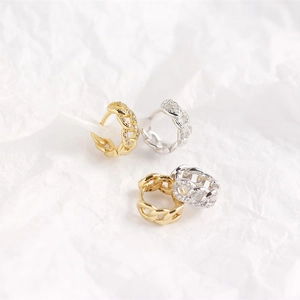 Macro shot of silver and gold geometric chain link hoop earrings with crystal pavé