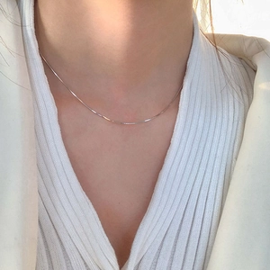 Close-up of a sleek S925 sterling silver snake chain necklace on a model's neck