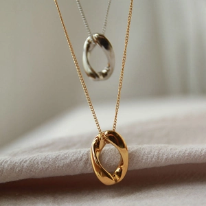 Minimalist twisted oval mobius pendant necklace in polished gold and silver metal finishes