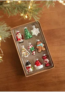 Detailed view of nine Christmas glass ornaments in a kraft box with a festive background