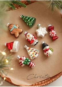 Close-up of assorted glass Christmas ornaments including snowman and tree in a basket