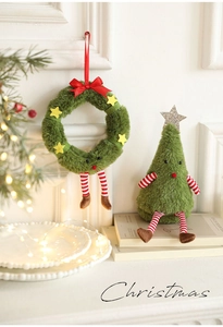 Dettaglio della bambola di albero di Natale in peluche e ghirlanda con decori festivi