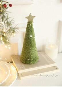 Dettaglio albero di Natale in peluche verde con stelle argentate e decoro festivo
