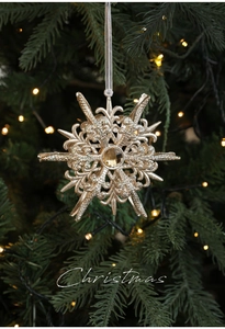 Détail de flocon de neige doré avec pierre précieuse sur un sapin de Noël