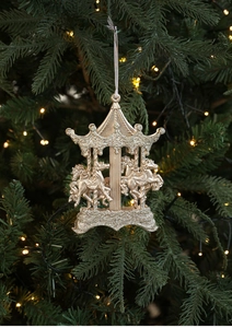 Détail du manège de Noël doré à paillettes suspendu aux branches du sapin décoré